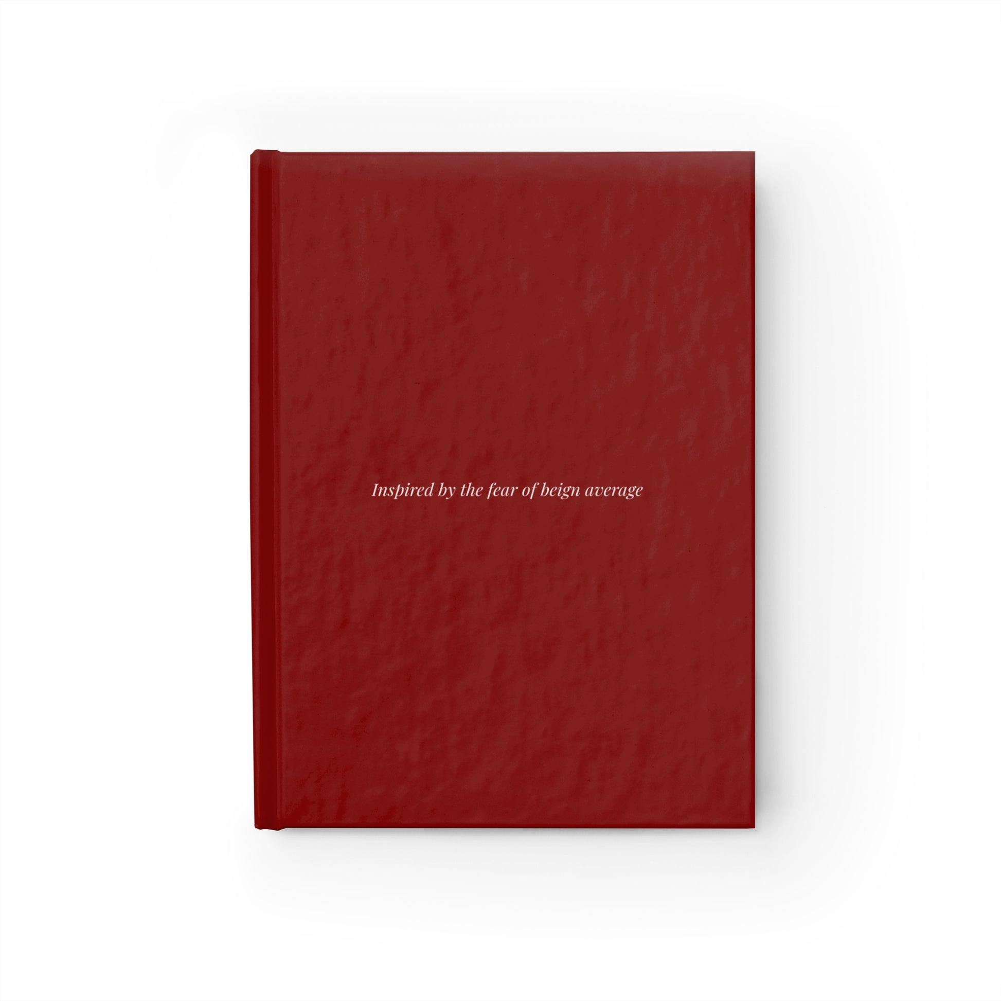 Burgundy hardcover journal with text inspired by the fear of being average